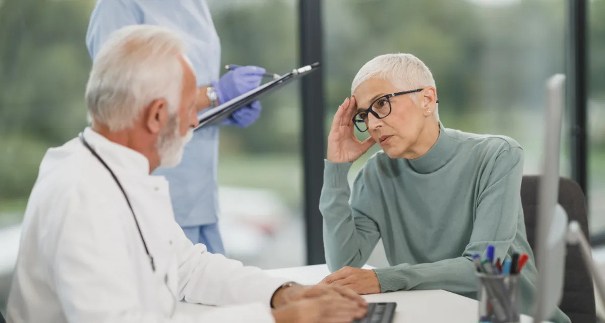 Homem adulto conversando com médico em consultório